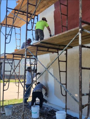 KGP crew applying finish from scaffolding
