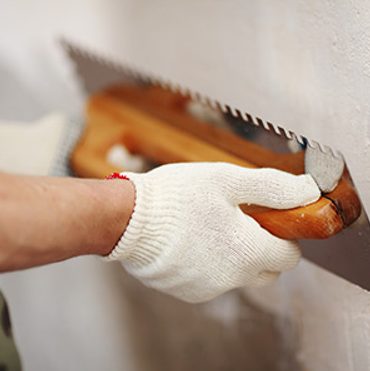 Plasterer troweling a wall